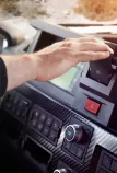 Driver touching the park brake on the Renault Trucks T High dashboard