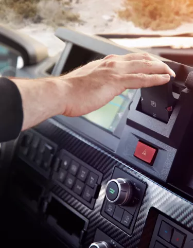 Driver touching the park brake on the Renault Trucks T High dashboard