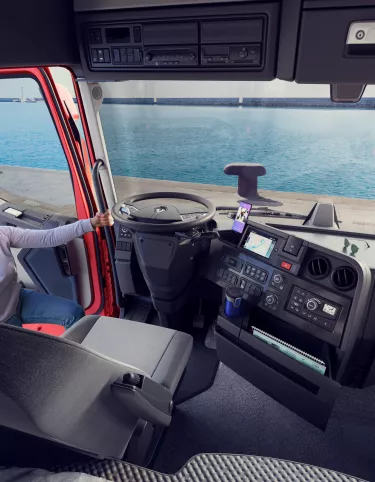 A driver gets into a Renault Trucks parked in a harbor.